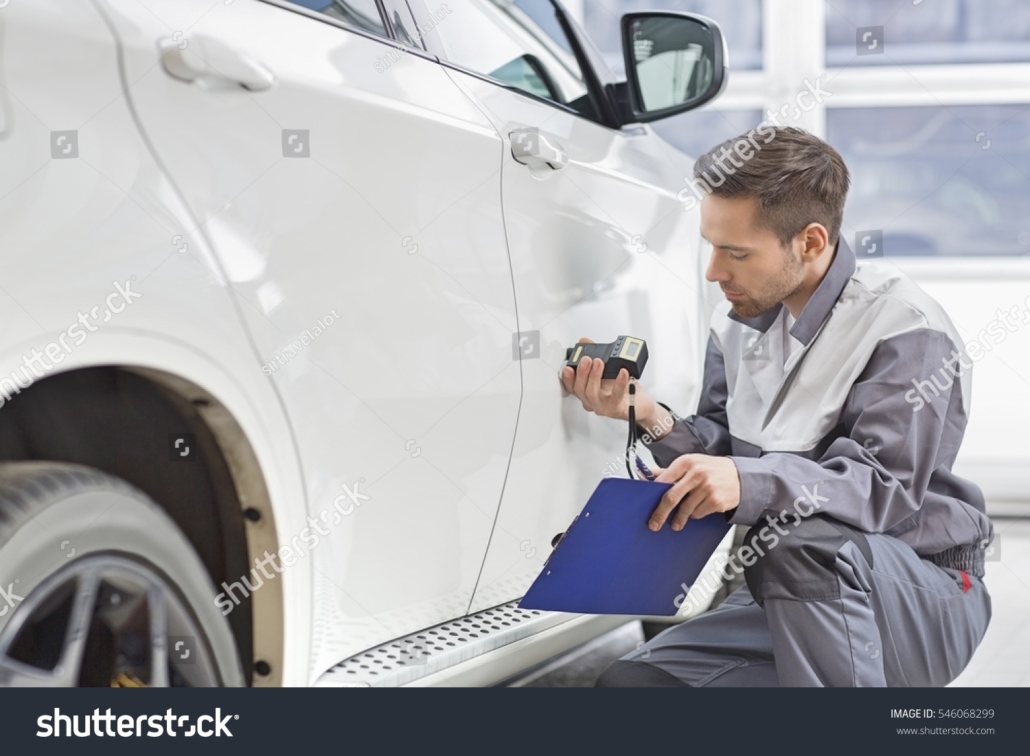 stock-photo-male-repair-worker-examining-car-paint-with-equipment-in-repair-shop-546068299